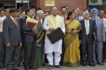 India's FM Jaitley poses as he leaves his office to present the federal budget for the 2014/15 fiscal year in New Delhi