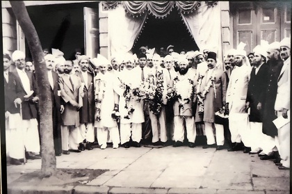 A 1942 group photograph taken just outside a hall in Dongri soon after the inauguration of the Anjuman-i-Pukhtoon Trust. In the centre (dressed in a suit) is Chief Guest Aziz Khan (Inspector of Police Pathan Branch CID), and to his left is Samad Khan (founder of the Trust) along with other community members.