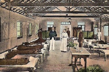 A postcard by Clifton & Co., c. 1903, showing a ward with patients and two medical personnel taken in a Plague Hospital in Bombay.