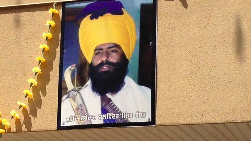 "Martyr" poster of Air India bomber Talwinder Singh Parmar, fixed to the exterior of the Dasmesh Darbar gurudwara in Surrey, British Columbia. The same photo, taken at a Pakistani gun market in 1989, was used by Sikhs for Justice to advertise its "Shaheed Talwinder Singh Parmar Voter Registration Centre."